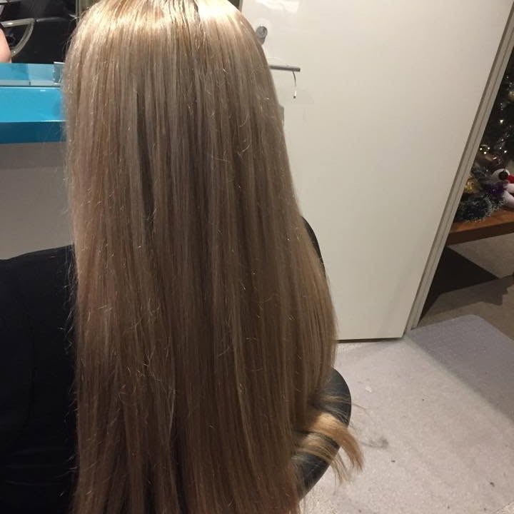 Long, glossy blonde-brown hair after a cut